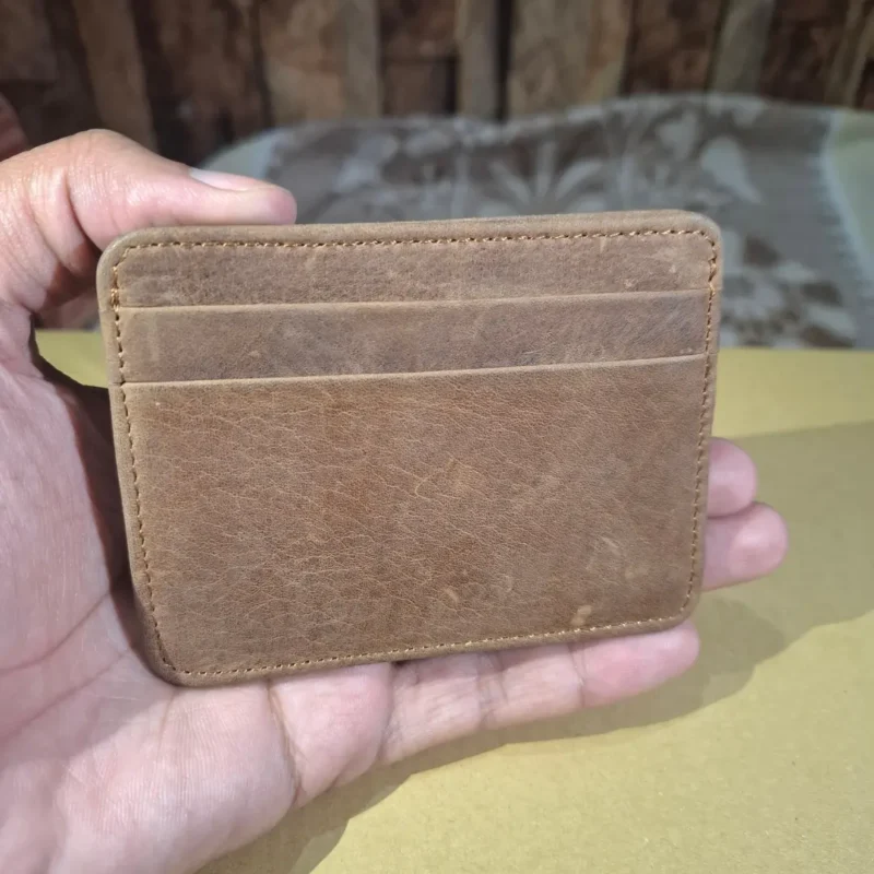 Slim 5-pocket leather card holder placed on a patterned fabric wolveyes